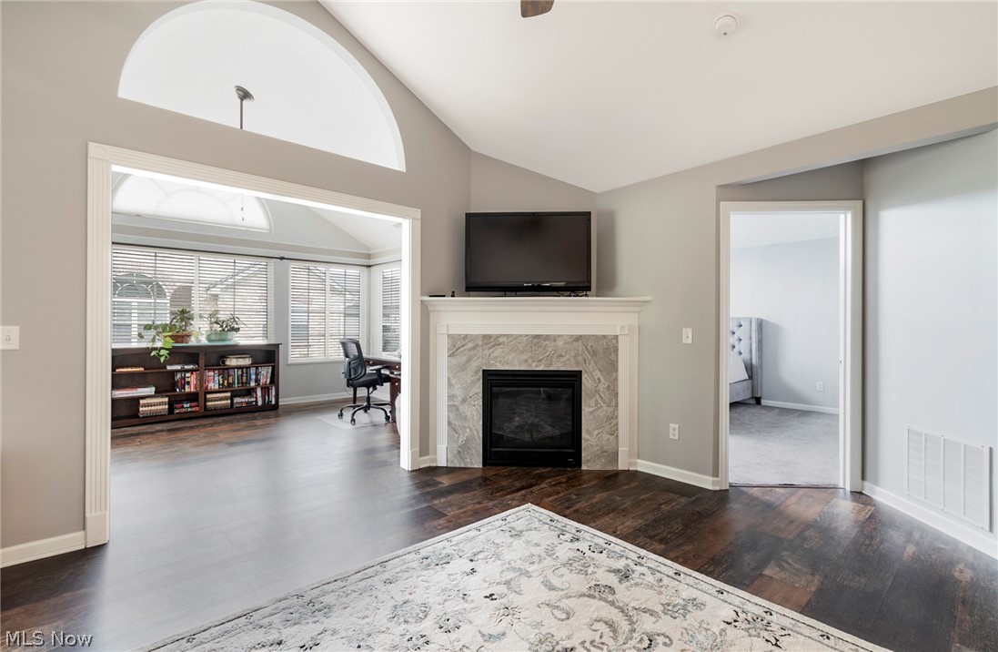 9151 Springfield Road, Unit 1902 Youngstown, OH 44514 - Photo 5 of 36 Unfurnished living room with a premium fireplace, vaulted ceiling, and dark hardwood / wood-style flooring