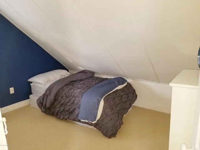 a bed sitting in a bedroom next to a bathroom