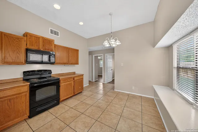 a kitchen with stainless steel appliances granite countertop a stove top oven a sink a counter space and cabinets