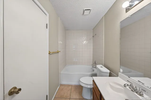 a bathroom with a toilet a sink a mirror and shower