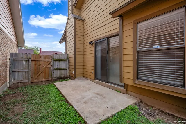 a view of backyard with barbeque grill potted plants and wooden fence