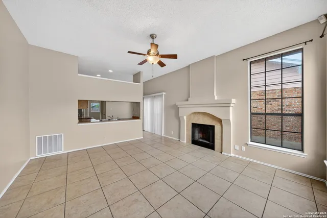 a view of an empty room with a fireplace and a window