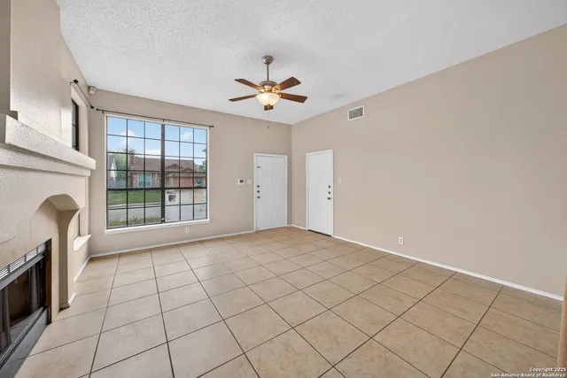 a view of an empty room with a fireplace and a window