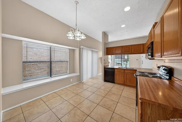 a open kitchen with stainless steel appliances granite countertop a refrigerator a sink a stove and a wooden cabinets