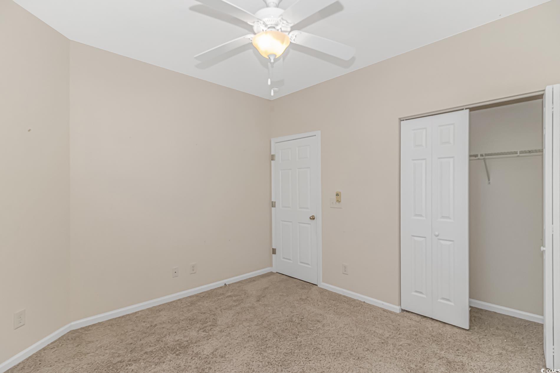 139 Chenoa Drive, Unit D Murrells Inlet, SC 29576 - Photo 22 of 34 Unfurnished bedroom with light colored carpet, a closet, and ceiling fan