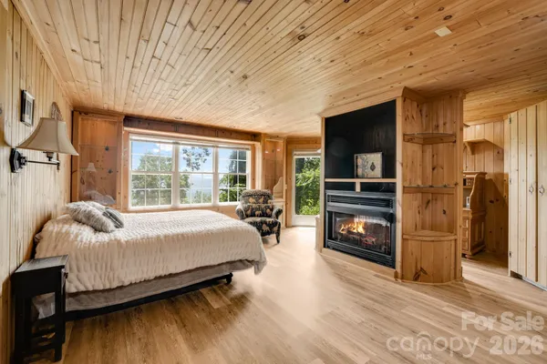 a bedroom with a bed flat screen tv and a large window