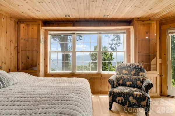 a bedroom with furniture and a large window