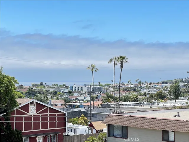 a front view of a building with streets and trees