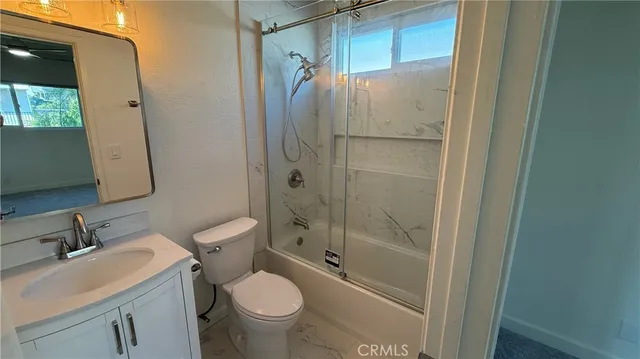 a bathroom with a shower a sink and a toilet