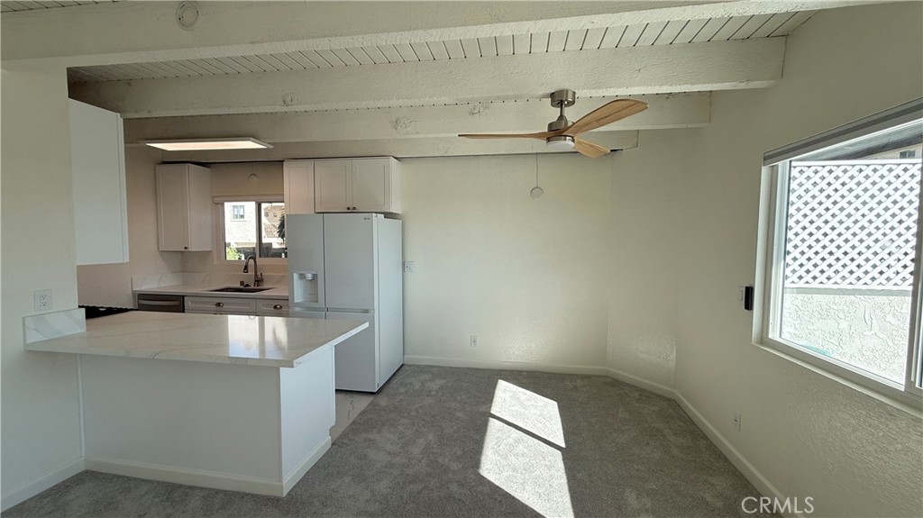 33852 Copper Lantern Street, Unit F Dana Point, CA 92629 - Photo 5 of 44 a kitchen with kitchen island a stove a faucet and a refrigerator