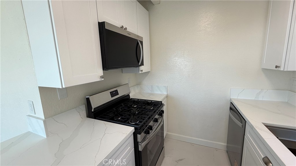 33852 Copper Lantern Street, Unit F Dana Point, CA 92629 - Photo 6 of 44 a kitchen with a stove and a microwave