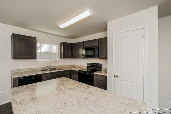 a kitchen with stainless steel appliances a sink dishwasher stove and refrigerator