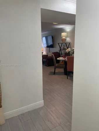 a view of a room with wooden floor furniture and a potted plant