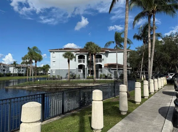 a view of a chairs and table under an umbrella with wooden fence