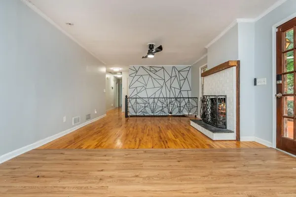 a view of empty room with wooden floor