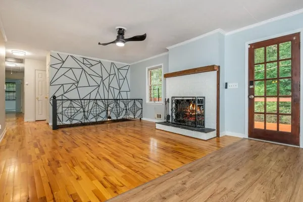 a view of a livingroom with wooden floor a fireplace and window