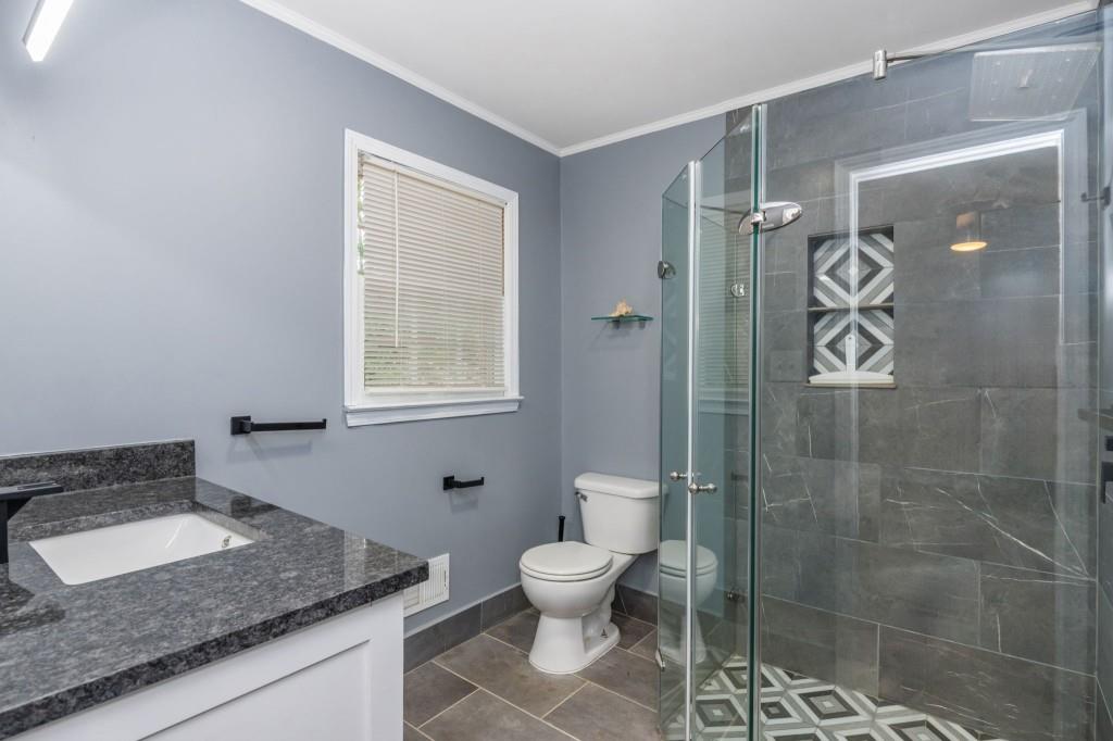 4043 Casa Loma Drive Decatur, GA 30034 - Photo 24 of 36 a bathroom with a granite countertop sink a toilet and shower