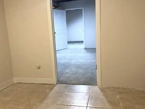 an empty room with a bench and cabinets