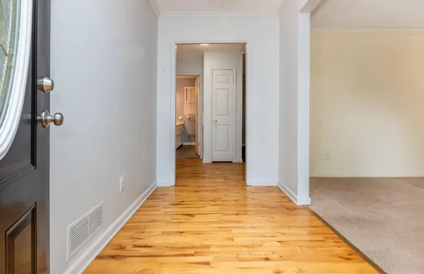 a view of a room with wooden floor and a bathroom
