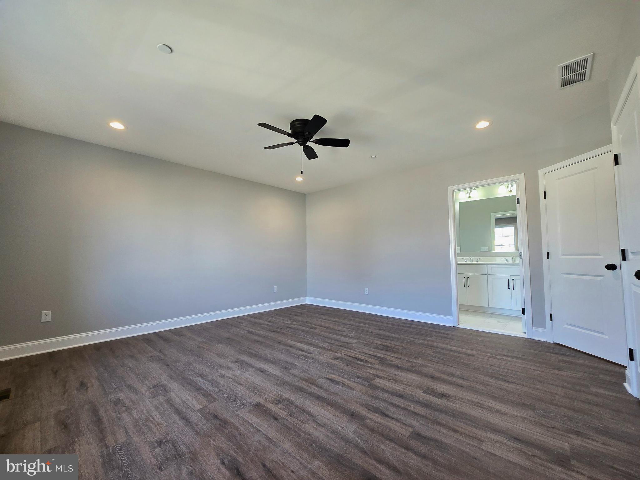 7704 Highpoint Road Clearwater Beach, MD 21226 - Photo 12 of 48 a view of an empty room with wooden floor and a ceiling fan