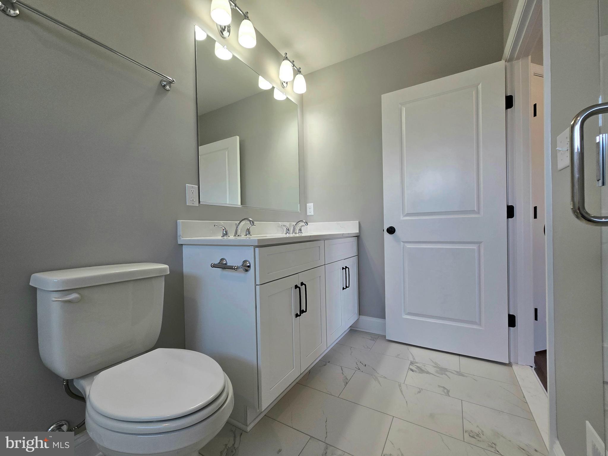 7704 Highpoint Road Clearwater Beach, MD 21226 - Photo 14 of 48 a spacious bathroom with a toilet a sink and a mirror
