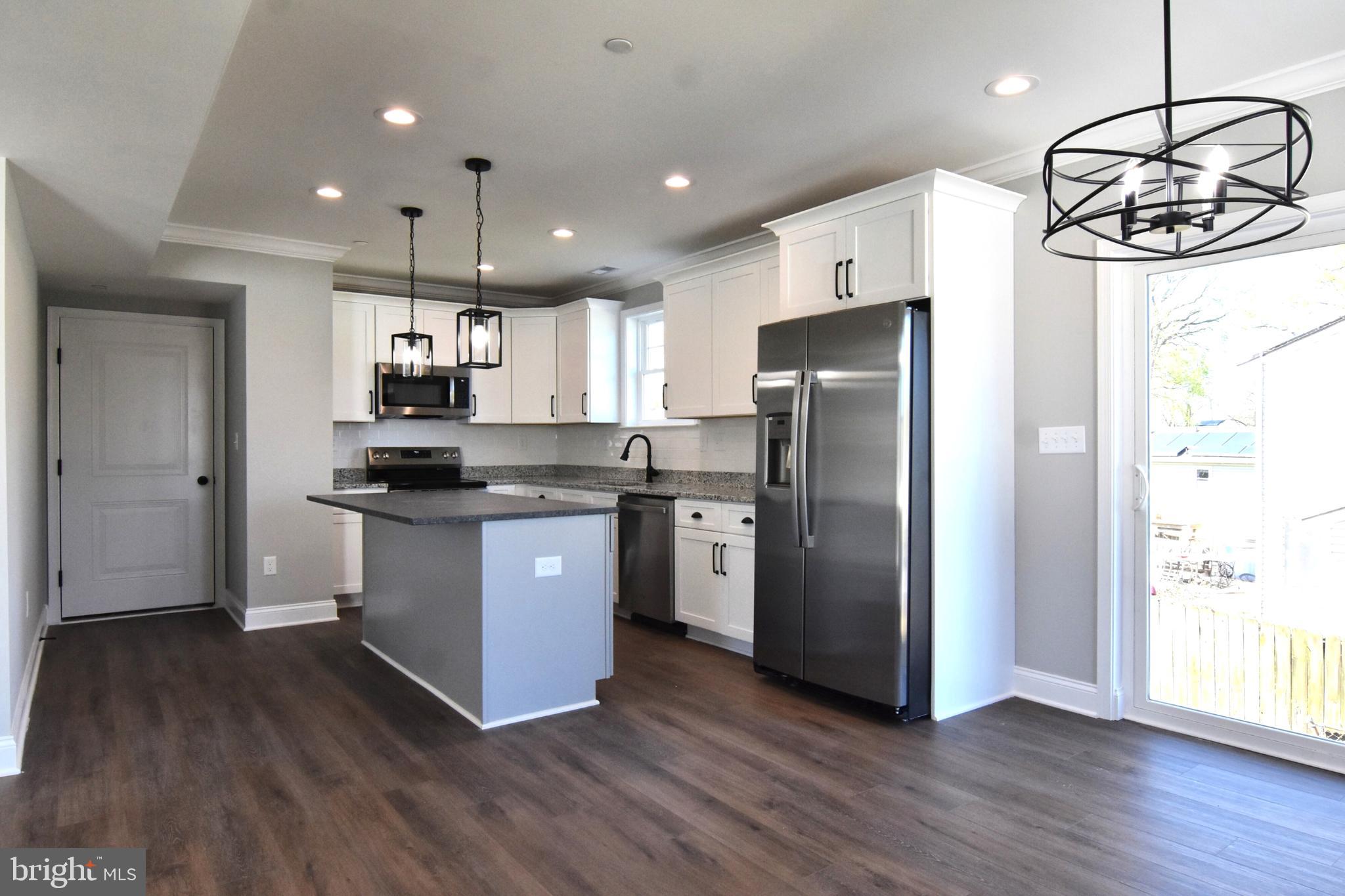 7704 Highpoint Road Clearwater Beach, MD 21226 - Photo 3 of 48 a kitchen with stainless steel appliances granite countertop a refrigerator a sink dishwasher a stove and white countertops with wooden floor