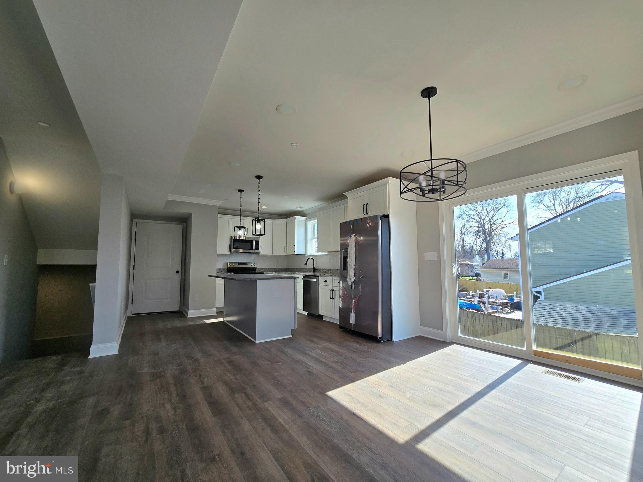 7704 Highpoint Road Clearwater Beach, MD 21226 - Photo 7 of 48 a kitchen with stainless steel appliances kitchen island a refrigerator and a wooden floor