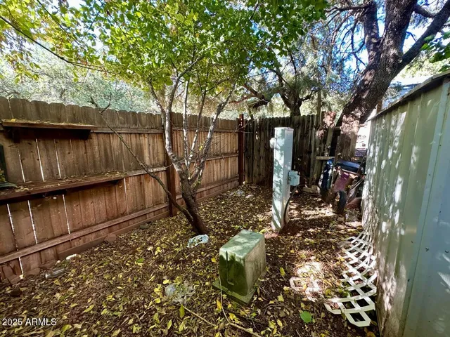 a view of a pathway of a yard with wooden fence
