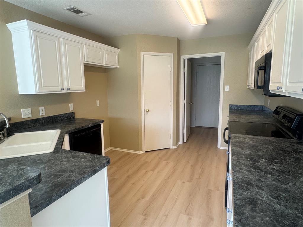 908 Cedar Ridge Lane Burleson, TX 76028 - Photo 7 of 24 a kitchen with granite countertop a sink a stove and cabinets