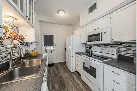 a kitchen with stainless steel appliances a stove sink microwave and cabinets