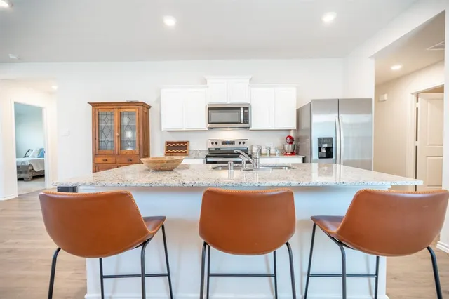 a kitchen with stainless steel appliances granite countertop a table and chairs