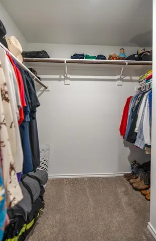 a view of walk in closet with clothes and shoes