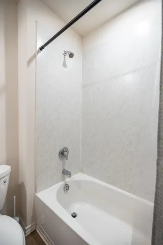 a white bath tub sitting next to a white toilet and a sink