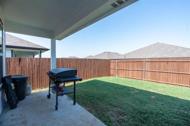 a view of backyard with seating area and wooden fence