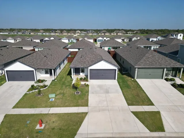 an aerial view of residential houses with outdoor space and ocean view