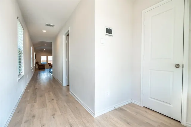 a view of a hallway with wooden floor