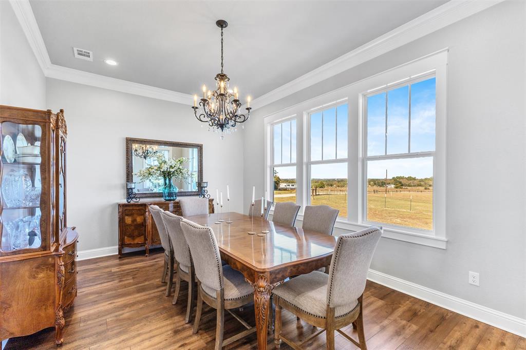 1694 Henry Prairie Road Franklin, TX 77856 - Photo 16 of 40 a view of a dining room with furniture a chandelier and wooden floor