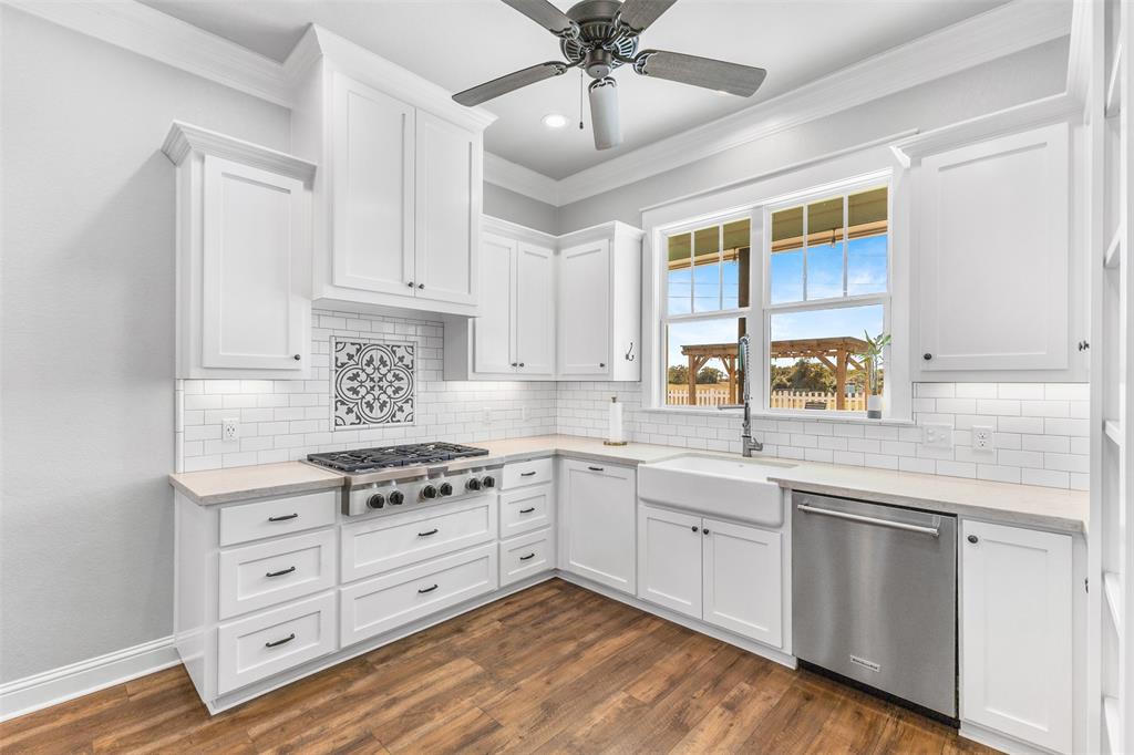 1694 Henry Prairie Road Franklin, TX 77856 - Photo 21 of 40 a kitchen with cabinets stainless steel appliances a sink and wooden floor