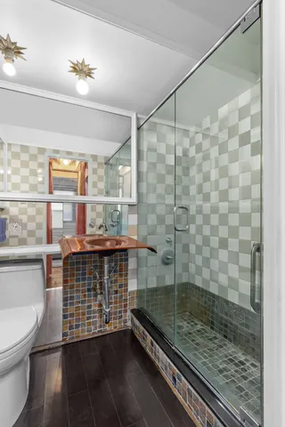 a bathroom with a granite countertop sink a toilet and shower