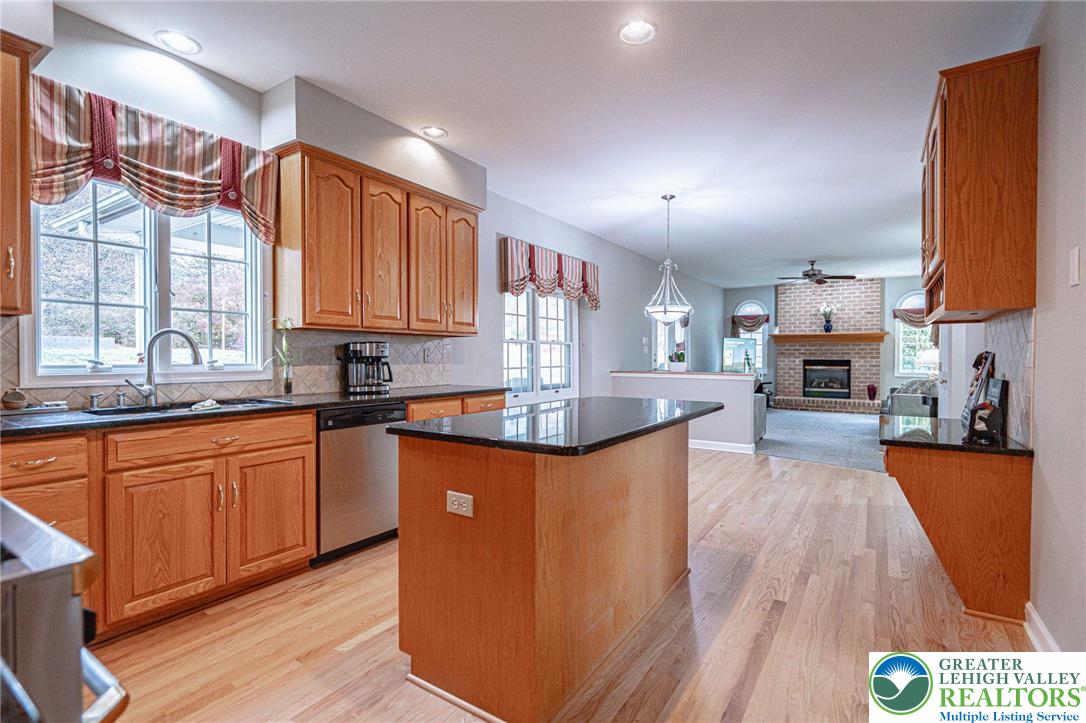6551 Overlook Road Orefield, PA 18069 - Photo 21 of 82 a kitchen with stainless steel appliances granite countertop a stove a sink dishwasher and a refrigerator with wooden floor
