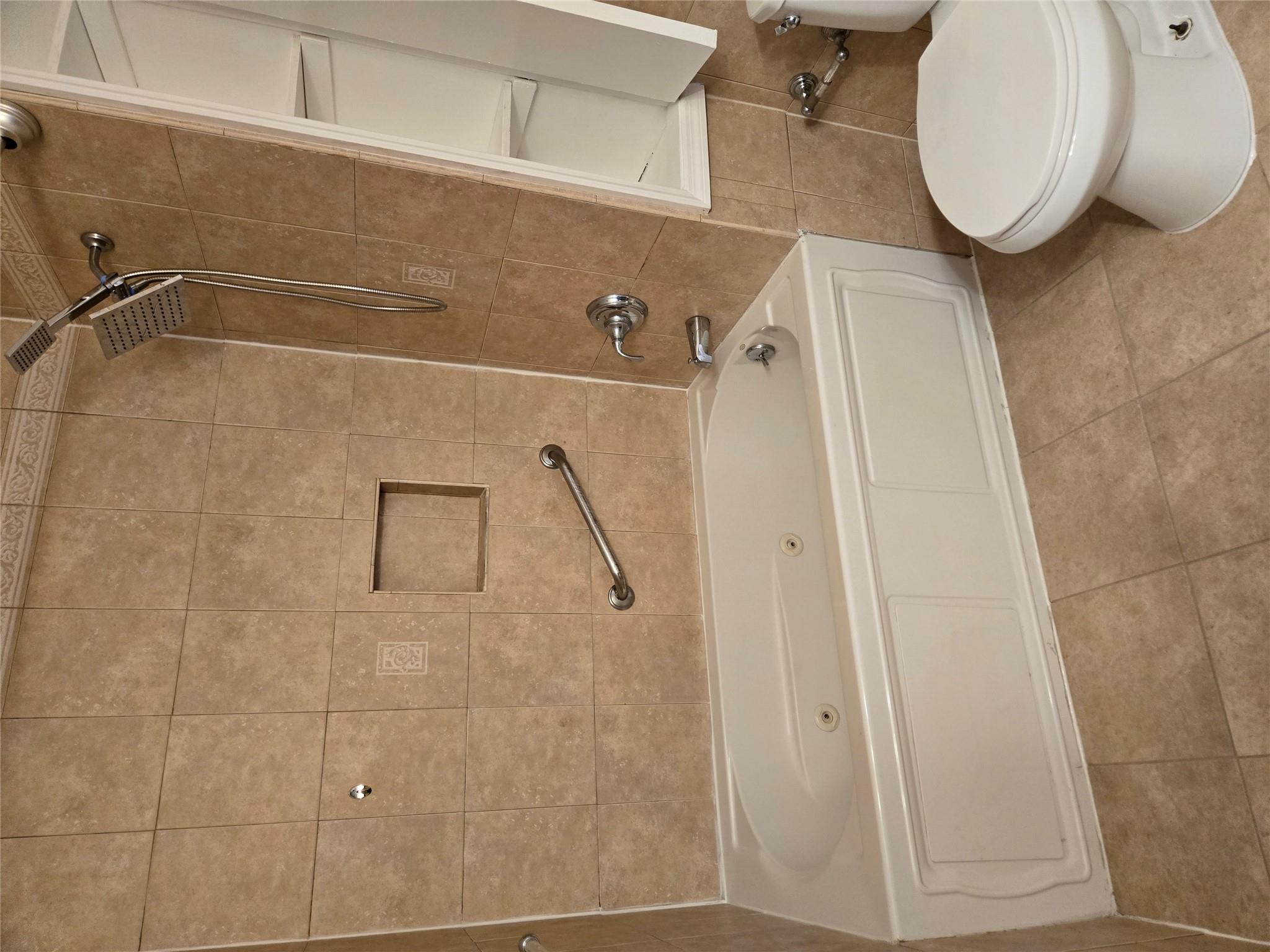 189-07 Quencer Road Queens, NY 11412 - Photo 14 of 36 a bathroom with a white toilet and a bathtub