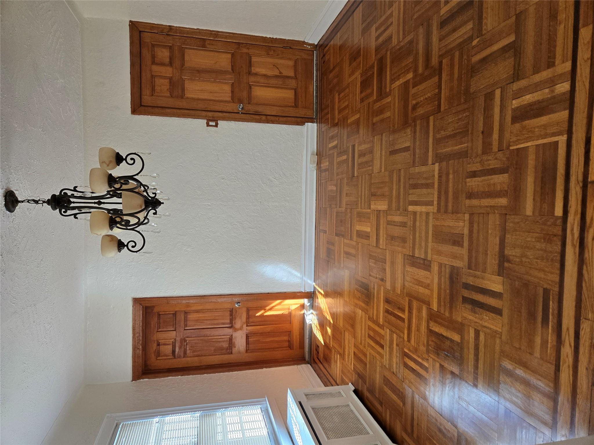 189-07 Quencer Road Queens, NY 11412 - Photo 6 of 36 a view of an empty room with wooden floor and a window