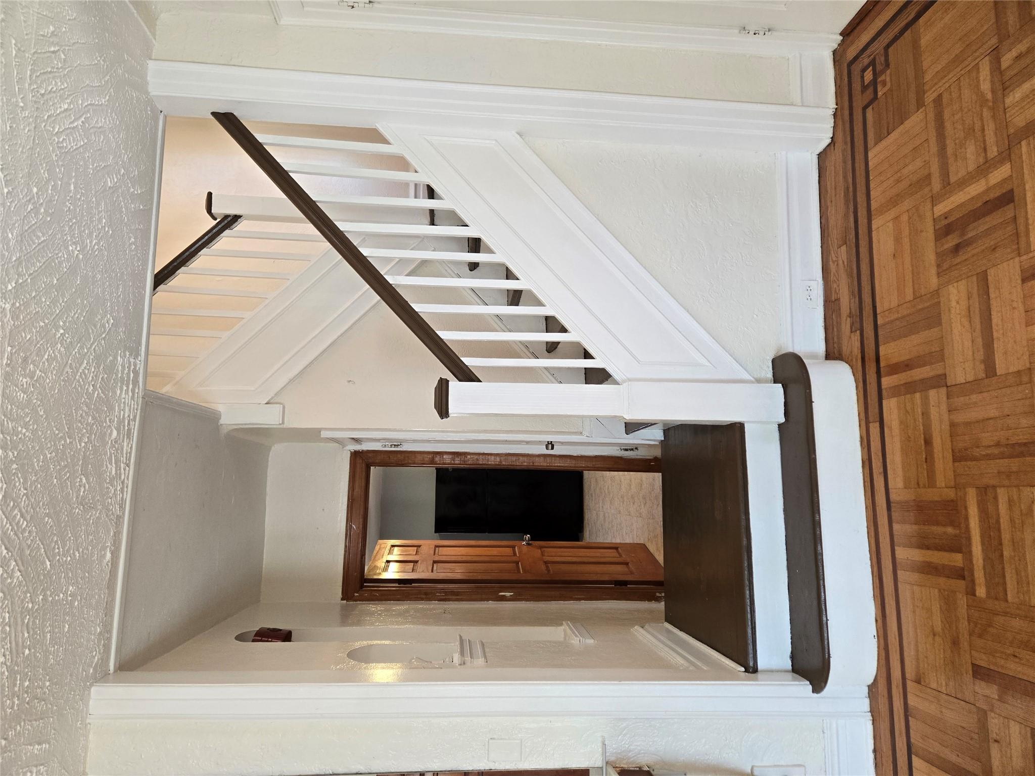 189-07 Quencer Road Queens, NY 11412 - Photo 7 of 36 a view of a hallway with wooden floor and staircase