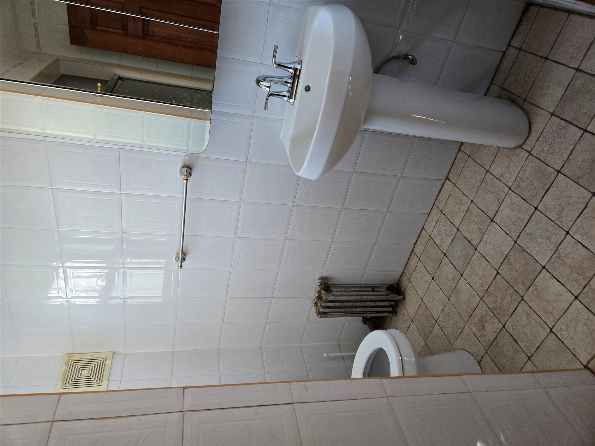 189-07 Quencer Road Queens, NY 11412 - Photo 9 of 36 a bathroom with a sink toilet and a mirror