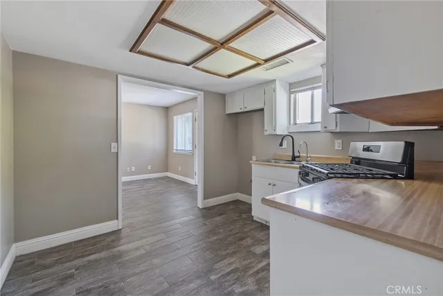 a kitchen with stainless steel appliances granite countertop a sink a stove and a wooden floors