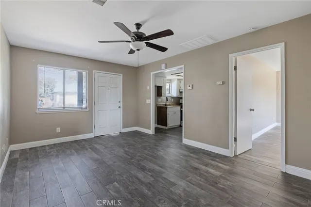 a view of empty room with wooden floor and window