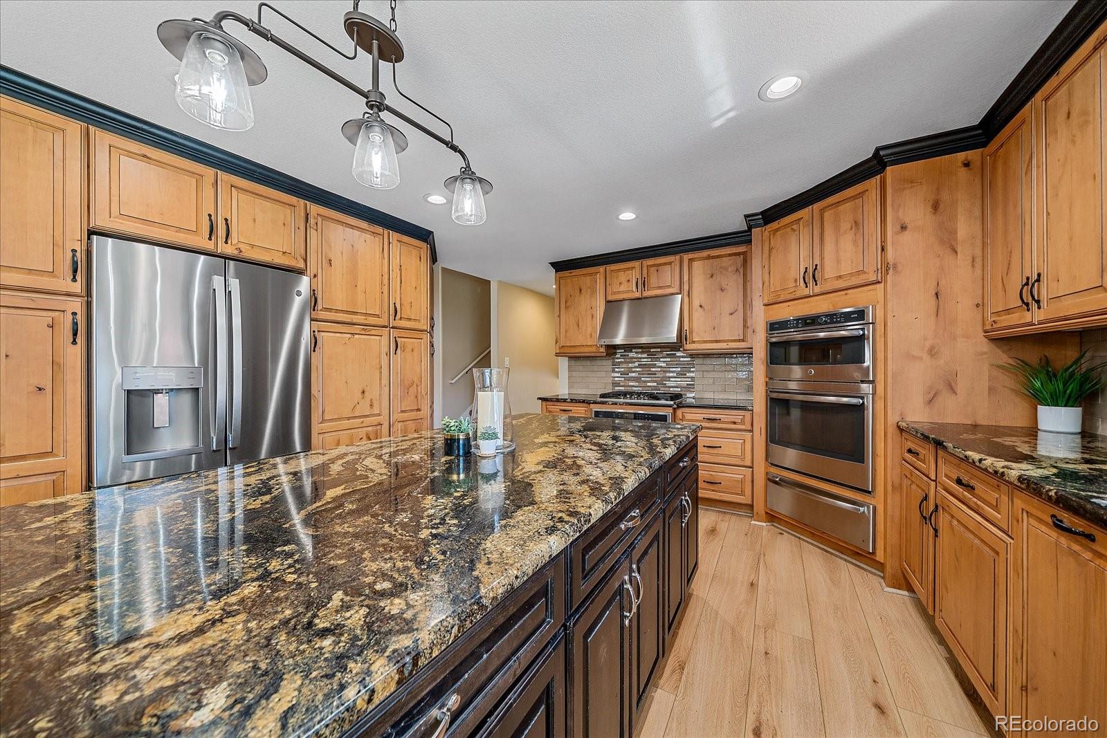 930 Reed Court Lakewood, CO 80214 - Photo 10 of 41 a kitchen with stainless steel appliances granite countertop a refrigerator a stove and a sink
