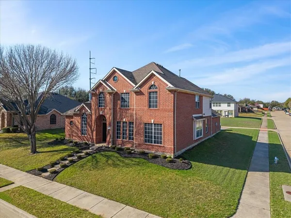 a view of a house with a big yard plants and large trees