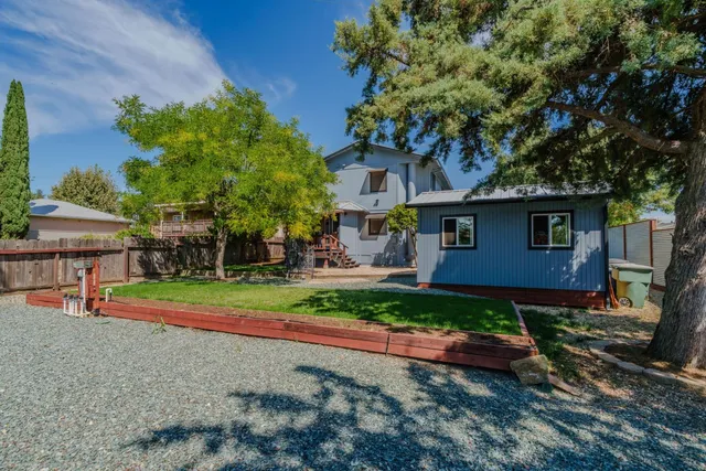 a view of a livingroom with a fireplace a ceiling fan and wooden floor