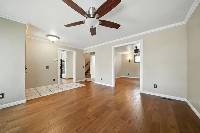 an empty room with fan and windows